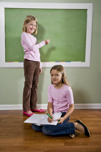 女孩们在黑板上写字和做作业
