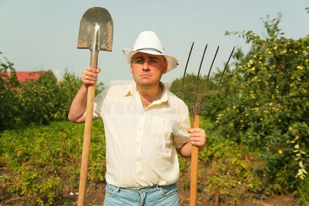 园丁用叉子和铲子摆姿势