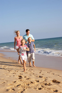 沙滩上奔跑的一家人的画像图片