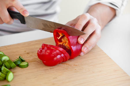 一名男子在厨房切红辣椒的特写镜头