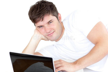 年轻帅哥趴着用电脑