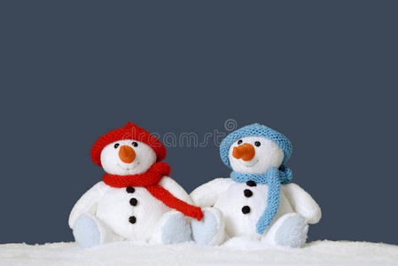 两个可爱的雪人坐在雪地里