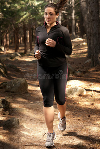 在树林里奔跑的年轻女子，户外背景