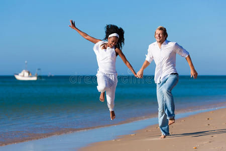 在海滩上散步和跑步的夫妇