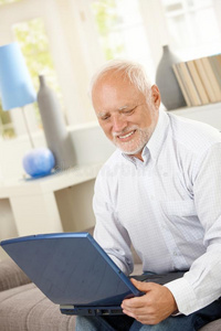 微笑的老人看着电脑屏幕