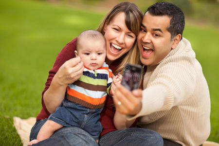 快乐的混血父母和带相机的男婴
