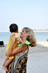 母亲在海滩牵着儿子