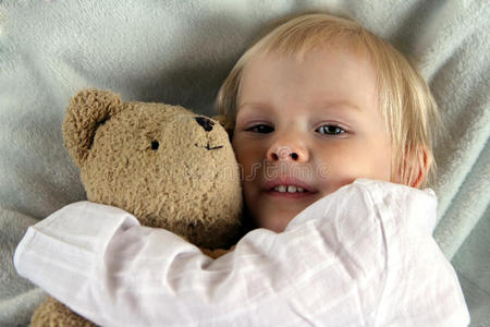 小孩和泰迪熊在床上