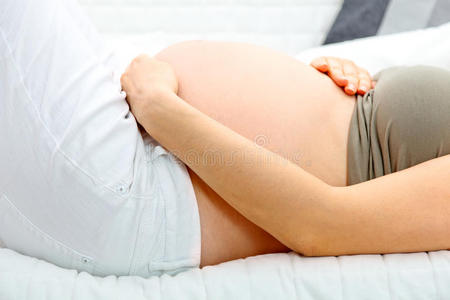 孕妇躺在沙发上抱着肚子