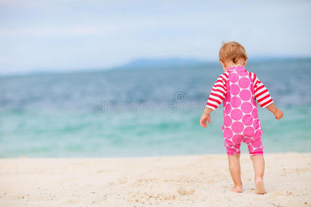 坐在白色沙滩上的小女孩