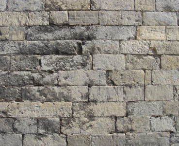 破旧的灰色和米色大石墙