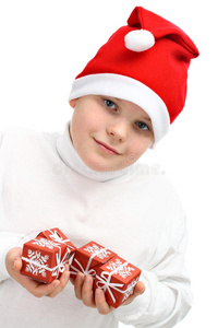 戴圣诞老人红帽子的男孩拿着圣诞礼物
