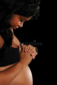怀孕祈祷的非洲裔美国年轻妇女
