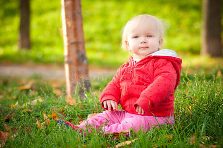 可爱欢快的婴儿坐在公园的草地上