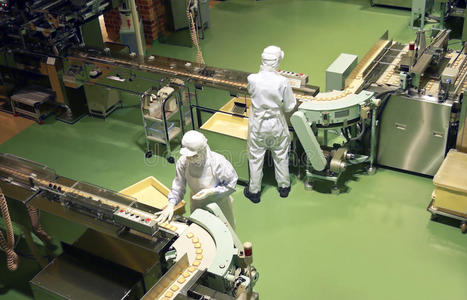 甜饼干的自动烘焙生产线蛋糕在自动传送带或线, 烘烤过程中的糖果厂