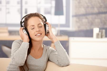 通过耳机欣赏音乐的年轻女子