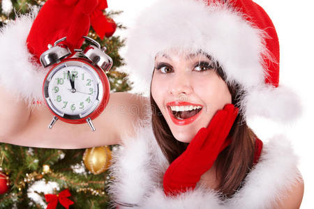 戴着圣诞帽拿着闹钟的女孩。