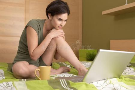 坐在床上看着笔记本电脑的女人