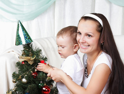 妈妈和女儿装饰一棵圣诞皮草树