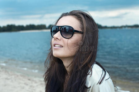 海滩上戴着太阳眼镜的年轻漂亮女孩