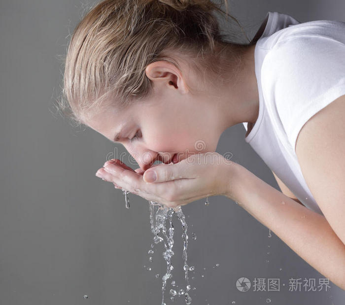 洗手洗脸液漂亮女孩在洗手手拿肥皂手中的肥皂有个女孩在洗手手便隔水