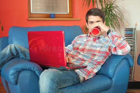 有吸引力的男人带着笔记本电脑喝咖啡