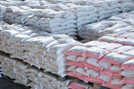 麻袋矗立在土地的肥料仓库中间成品工厂仓库钢材料成品仓库生产车间