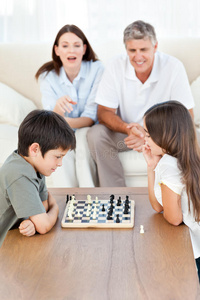 父母看着孩子下棋