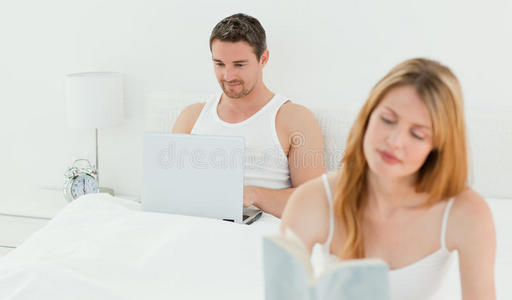 当他妻子在看书时，他在笔记本上