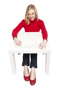坐在有趣的小桌子旁的年轻女子图片
