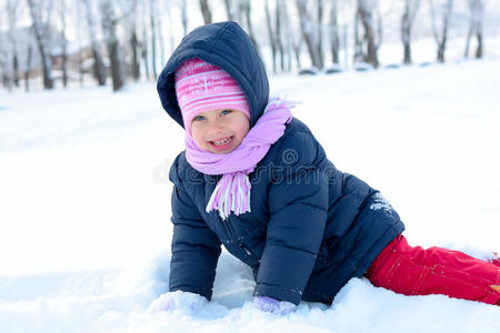 雪地公园里戴着冬天粉红色帽子的小女孩