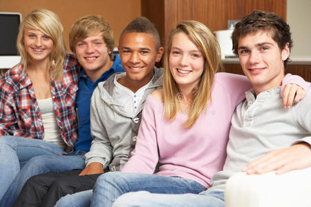 年轻的创造性的男性和女性同事团队在现代室内坐在红色沙发上, 青少年