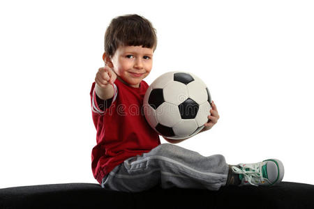 孩子坐在足球旁边