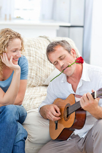 在家为妻子弹吉他的浪漫男人图片