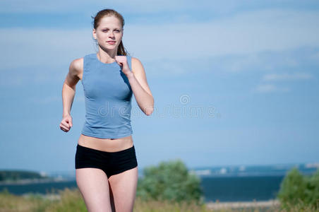 晴天跑步的年轻女运动员