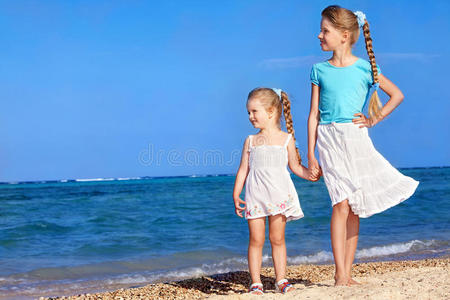 孩子们手牵着手在海滩上散步。