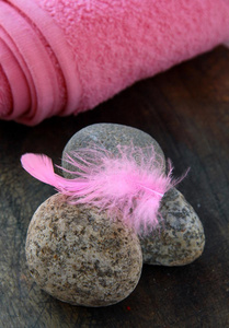石头上的粉色羽毛和粉色毛巾图片