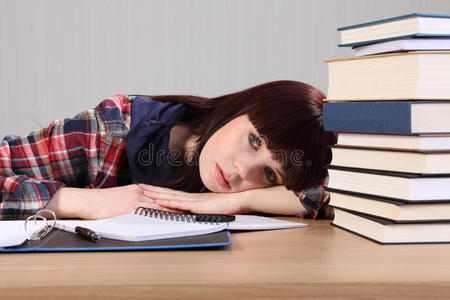 年轻的学生因作业累得头朝桌子