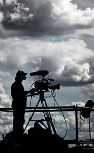 电视摄像师在多云天空中的剪影