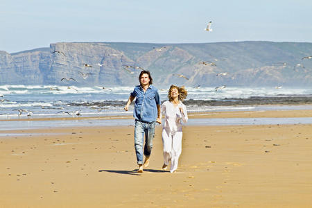 在海滩上跑步的年轻夫妇