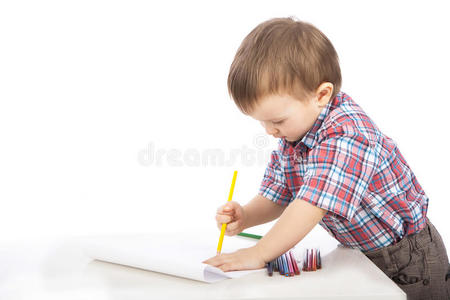 桌旁的一个小男孩画彩色铅笔