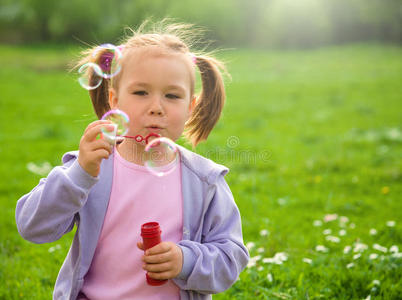 小女孩在草地上吹肥皂泡