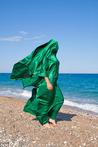 海滩上绿色纸巾女孩的剪影