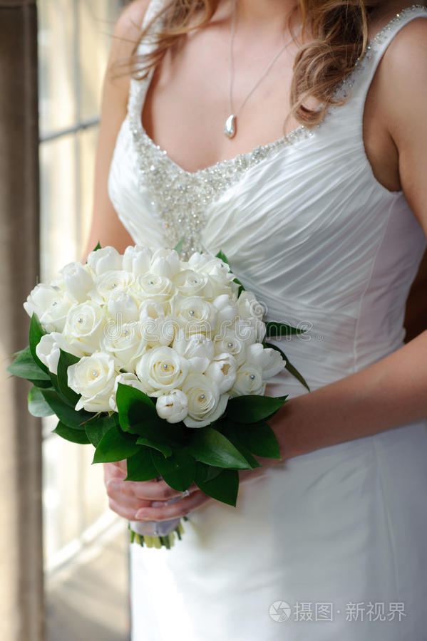 新娘拿着白色玫瑰