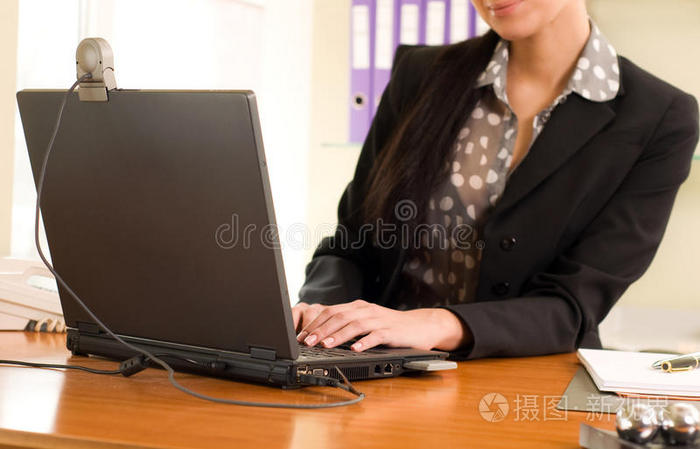 坐在办公室笔记本电脑前的女人