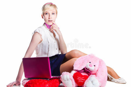金发女孩和粉色笔记本电脑一起工作