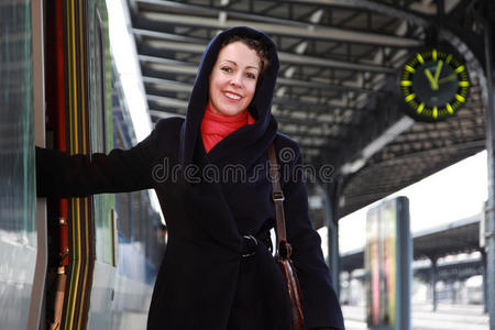 一个微笑着的年轻女子要上火车了。