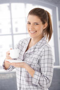 穿着睡衣拿着咖啡杯的快乐女人图片