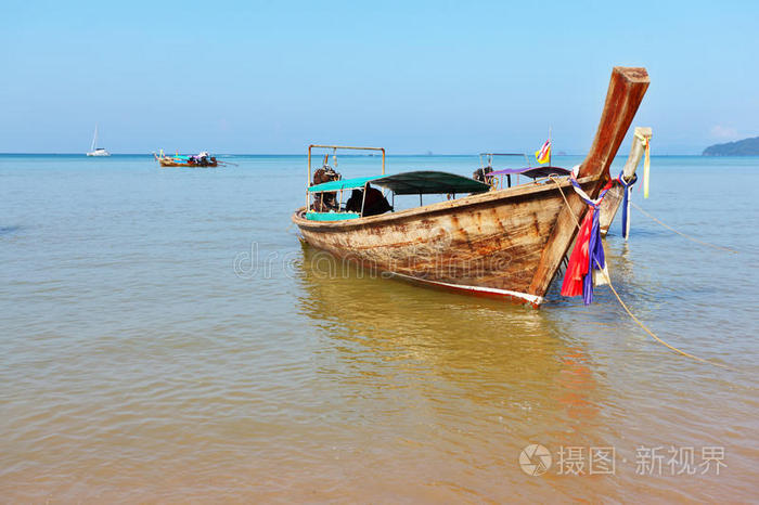 橙色沙滩上的长尾船