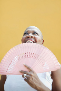 成熟的非洲女人，带着扇子，微笑着